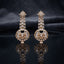 Gold CZ Star and Marquise Cascade Waterfall Sunburst Ball Globe Drop Earrings on dark mirror surface with navy charcoal satin backdrop showing 22K gold-tone pair with 8-pointed marquise white CZ star stud triple-strand marquise briolette CZ cascade waterfall stem and large open-work sunburst ball globe with baguette CZ bars champagne kite solitaires micro-pave rim and champagne CZ cabochon drop
