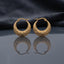 Gold Diamond-Cut Engraved Starburst Crescent Basket Hoop Earrings pair standing upright on dark mirror surface with charcoal slate satin backdrop showing 22K antique gold-tone wide crescent basket hoops with intricate diamond-cut engraved front face featuring parallel hatching upper half and twin 8-pointed starburst medallion engravings lower half with sharp mirror reflection below