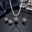 Gold-Tone 3D Dome Ball Pavé White CZ Pearl Chain Necklace, Earrings & Ring Jewelry Set on black reflective surface with navy blue silk fabric and crystal perfume bottle backdrop