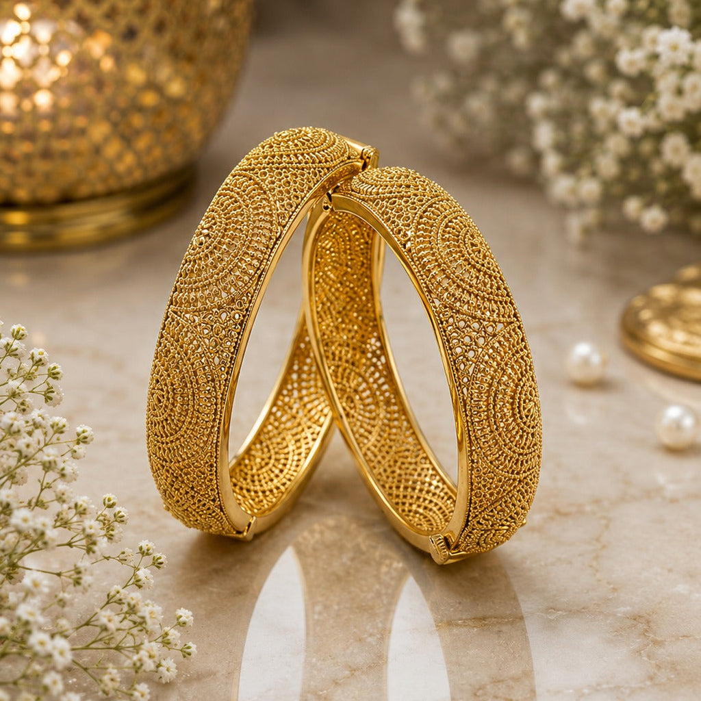 Gold-Tone Wide Dome Granule Filigree Mandala Kada Bangle Set of 2 on marble surface with gold lantern, pearls and baby's breath flowers backdrop