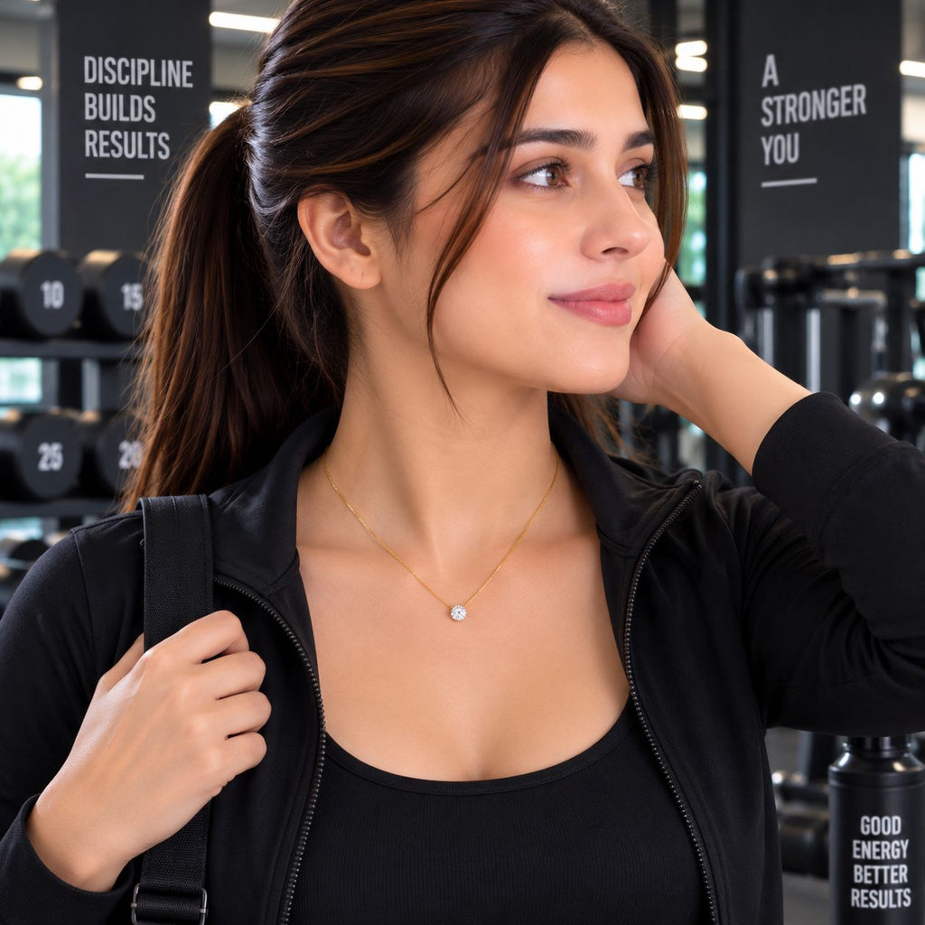 Gold Round Brilliant CZ Solitaire Floating Pendant Necklace worn by model in black gym jacket at gym setting with dumbbell rack backdrop