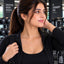 Gold Round Brilliant CZ Solitaire Floating Pendant Necklace worn by model in black gym jacket at gym setting with dumbbell rack backdrop