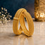 Gold-Tone Filigree Braided Kada Bangle Set of 2 on marble surface with blue backdrop and white baby's breath flowers