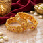 Gold-Tone Filigree Floral Ruby & White CZ Wide Kada Bangle Set of 2 on marble surface with maroon velvet, gold lantern and jasmine flowers backdrop
