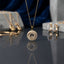 Gold Floating CZ Happy Diamond Circle Pendant Necklace in 18K gold-tone plating on dark grey mirror surface with blue silk and marble backdrop showing large round disc pendant with dense micro-pave white CZ outer ring and inner dome with smooth recessed circular channel containing two floating round CZ solitaire stones on fine gold cable chain with mirror reflection below and gold lock pendants and CZ rings in background