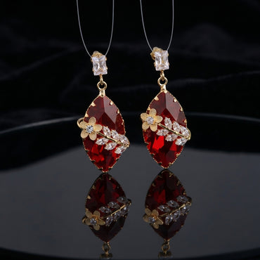 Gold Floral CZ Leaf Crystal Gem Drop Earrings in Smoky Mauve showing pair suspended on monofilament wire against dark silk backdrop with baguette CZ stud top large faceted diamond-shape smoky mauve crystal drop with gold daisy flower and marquise CZ leaf sprig overlay and mirror reflection below