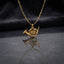 Gold French Horn Music Charm Pendant Necklace flat lay on grey reflective mirror surface with dark navy charcoal satin backdrop showing fine gold cable chain with highly detailed 3D miniature French horn musical instrument charm in matte satin gold tone finish with etched rotary valve detail and mirror reflection below