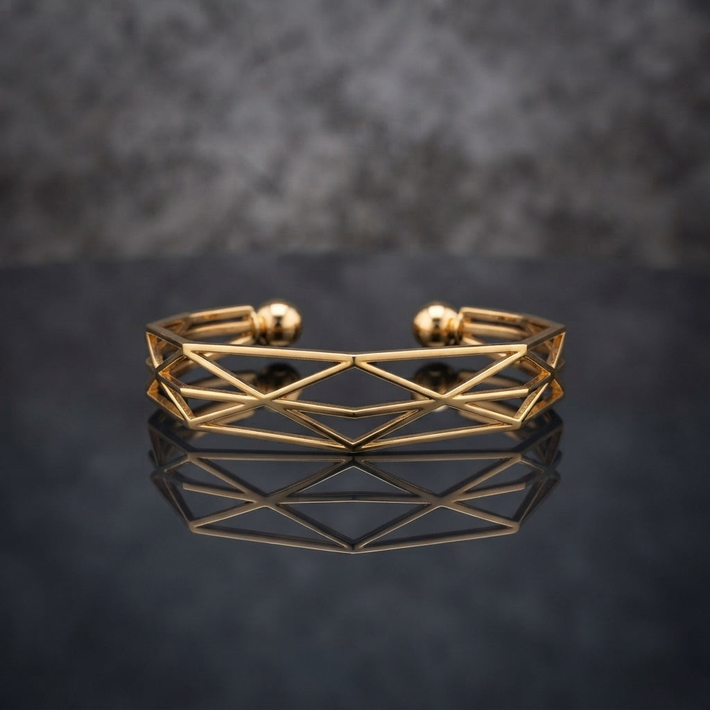 Gold Geometric Wireframe Diamond Lattice Open Cuff Bangle in 18K gold-tone PVD stainless steel on dark mirror surface with grey bokeh backdrop showing wide open C-shape cuff with repeating diamond rhombus X-cross geometric lattice wireframe pattern and two smooth gold ball bead finials at open ends with mirror reflection below