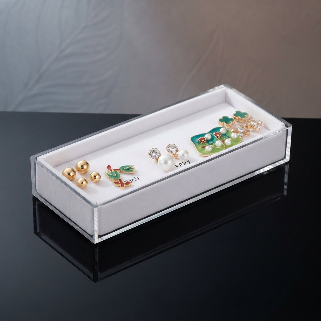 Gold Green Floral Enamel Pearl CZ 4-Pair Stud Earring Set displayed in open clear acrylic gift box on black surface with grey and beige fabric backdrop showing all four pairs arranged on white velvet insert with mirror reflection below