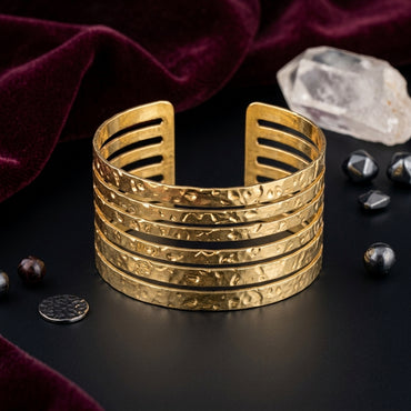 Gold-Tone Hammered Texture 5-Row Open Slot Cuff Wide Statement Bracelet on black mirror surface with white crystal quartz and scattered hematite stones with burgundy velvet backdrop
