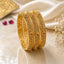 Gold-Tone Herringbone Filigree & Ruby CZ Sunflower Bangle Set of 4 stacked on cream marble surface with white silk fabric, ruby gemstones and baby's breath flowers backdrop