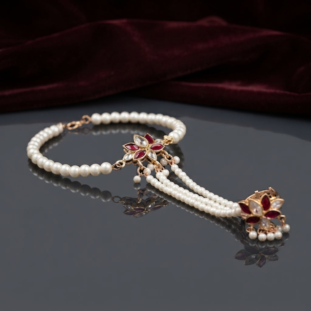 Gold Kundan Lotus Pearl Hath Phool Hand Harness Bracelet Ring in White Ivory variant worn by Pakistani female model in blush pink bridal outfit showing white MOP kundan lotus hath phool with fine pearl bracelet and 3 strand seed pearl hand chain connecting to finger ring in luxury bridal boutique backdrop