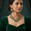 Gold Kundan Polki Ruby Emerald Pearl Choker Necklace Earrings Bridal Set — model wearing 22K antique gold ruby emerald kundan polki choker necklace and matching chandelier earrings, teal damask backdrop in Mughal heritage editorial setting