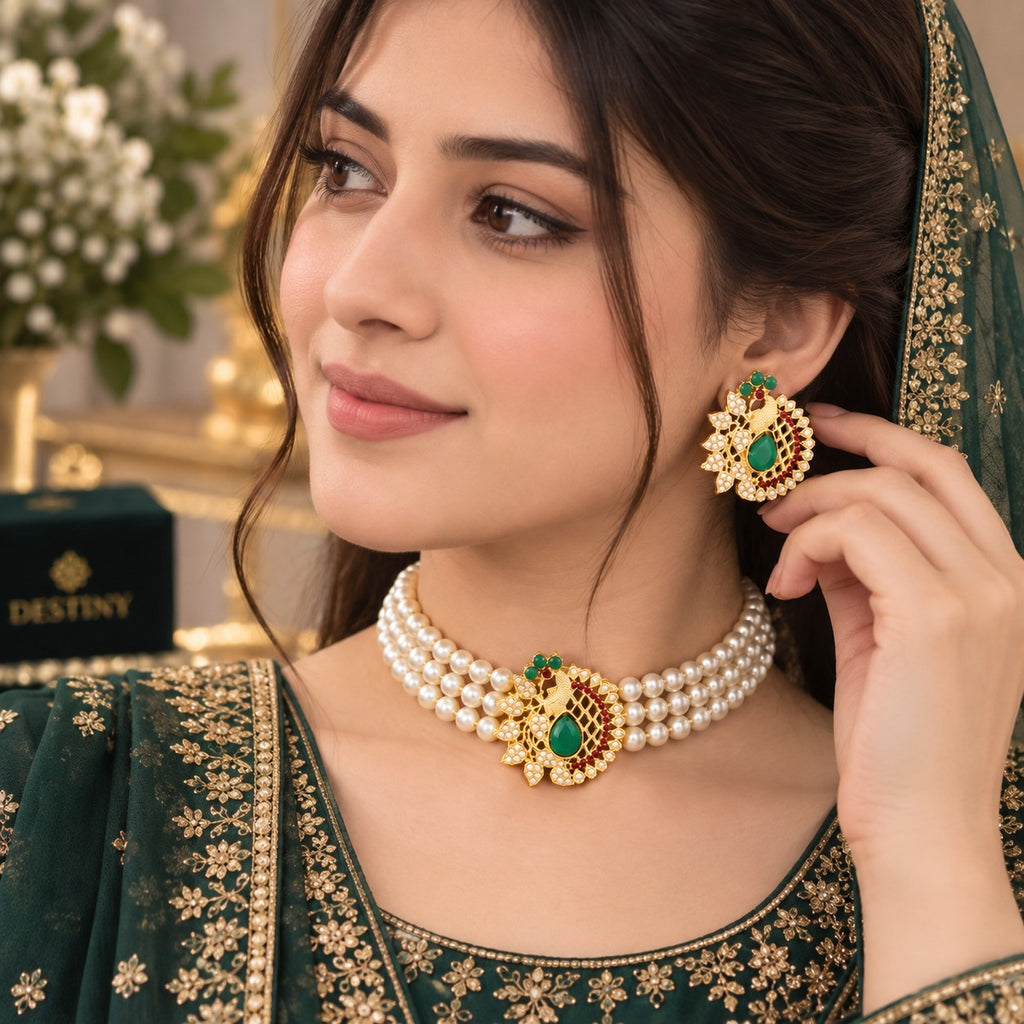 Gold-Tone Kundan Ruby Red & Emerald Green CZ Diamond Lattice Centrepiece 3-Strand Pearl Choker Necklace & Earrings Set worn on bridal model in dark green embroidered lehenga with dupatta and floral backdrop