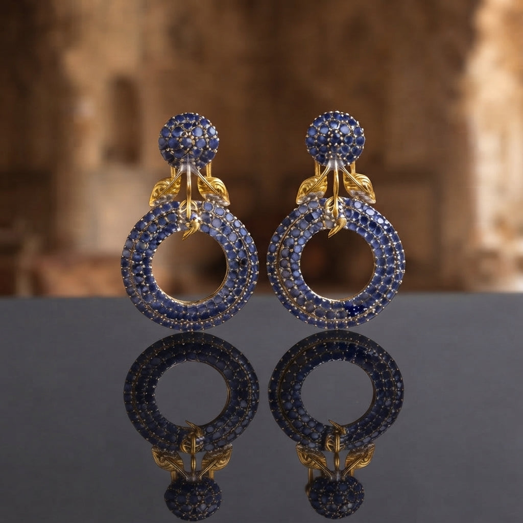 Gold Leaf CZ Pavé Circle Drop Earrings in Emerald Green color in 18K gold-tone plating on grey mirror surface with Mughal archway backdrop showing round dome ball stud top and large open circle drop fully covered in dense emerald green micro-pavé CZ stones with gold leaf connector and mirror reflection below