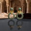 Gold Leaf CZ Pavé Circle Drop Earrings in Blue Sapphire color in 18K gold-tone plating on dark grey mirror surface with Mughal palace backdrop showing round dome ball stud top and large open circle drop fully covered in dense blue sapphire micro-pavé CZ stones with gold leaf connector and mirror reflection below