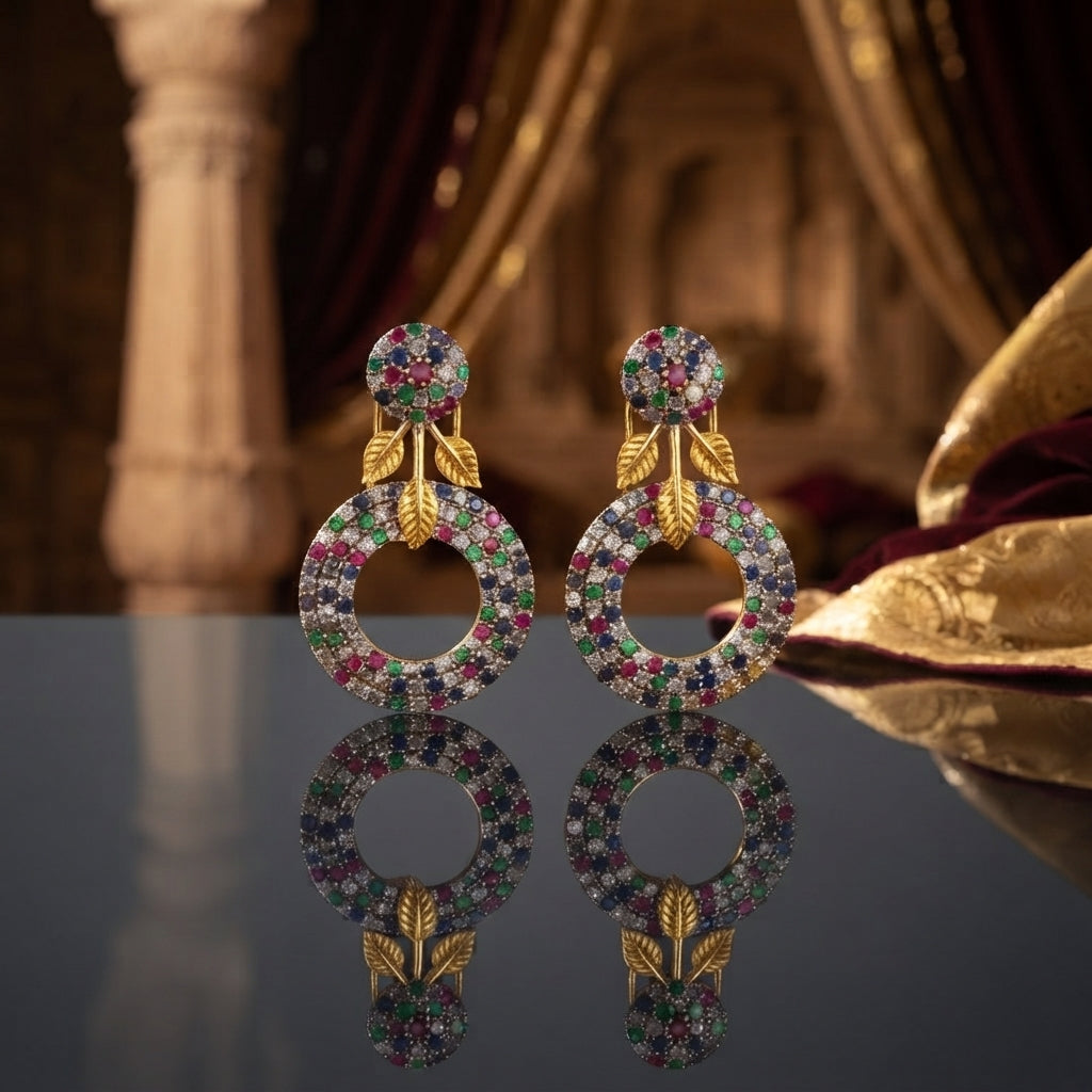 Gold Leaf CZ Pavé Circle Drop Earrings in Ruby Pink color in 18K gold-tone plating on dark mirror surface with warm Mughal palace backdrop showing round dome ball stud top and large open circle drop fully covered in dense ruby pink micro-pavé CZ stones with gold leaf connector and mirror reflection below