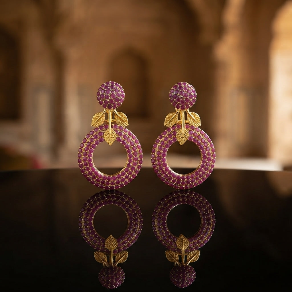 Gold Leaf CZ Pavé Circle Drop Earrings in Turquoise Blue color in 18K gold-tone plating on dark black tray surface with warm interior Mughal backdrop showing round dome ball stud top and large open circle drop fully covered in dense turquoise blue micro-pavé CZ stones with gold leaf connector and mirror reflection below
