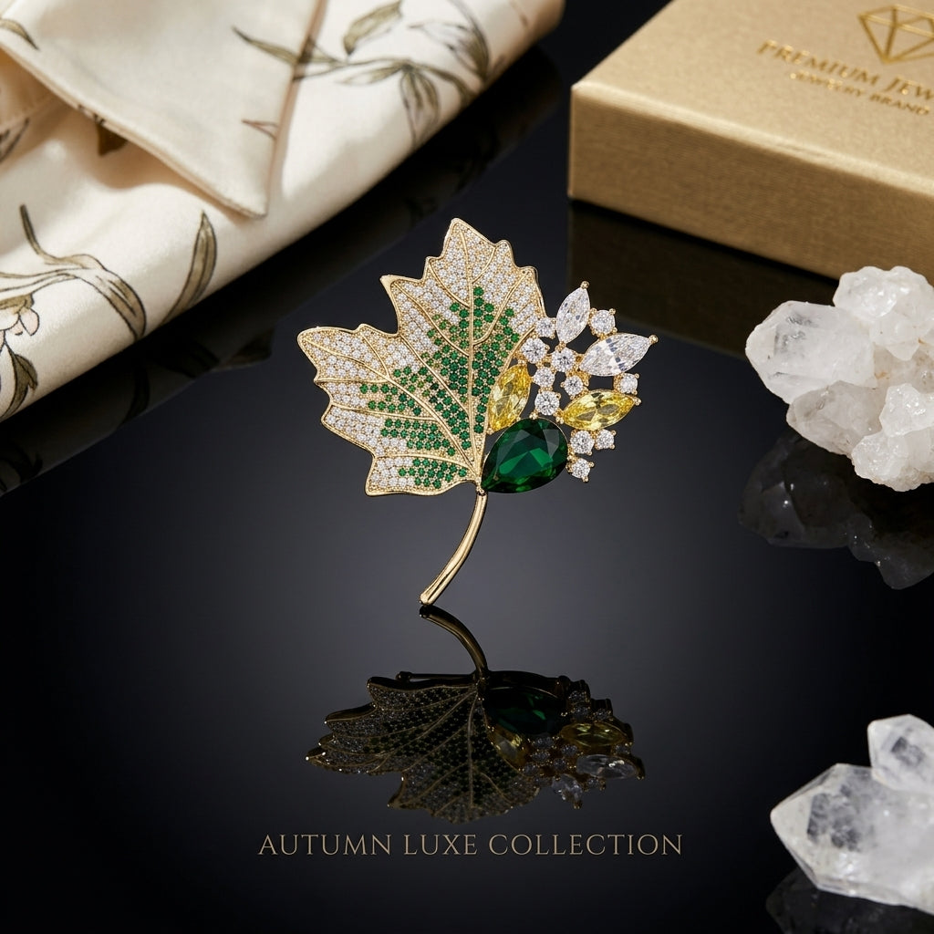 Gold-Tone Maple Leaf Pavé Emerald & Multicolor CZ Luxury Brooch on black reflective surface with white quartz crystal clusters and Premium Jewelry luxury brand box backdrop