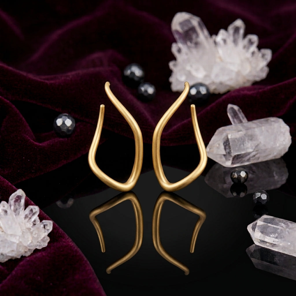 Gold-Tone Matte Sculptural Tulip Flame Open Teardrop Wishbone Long Drop Earrings on black mirror surface with white crystal quartz clusters, black hematite beads and deep burgundy velvet backdrop