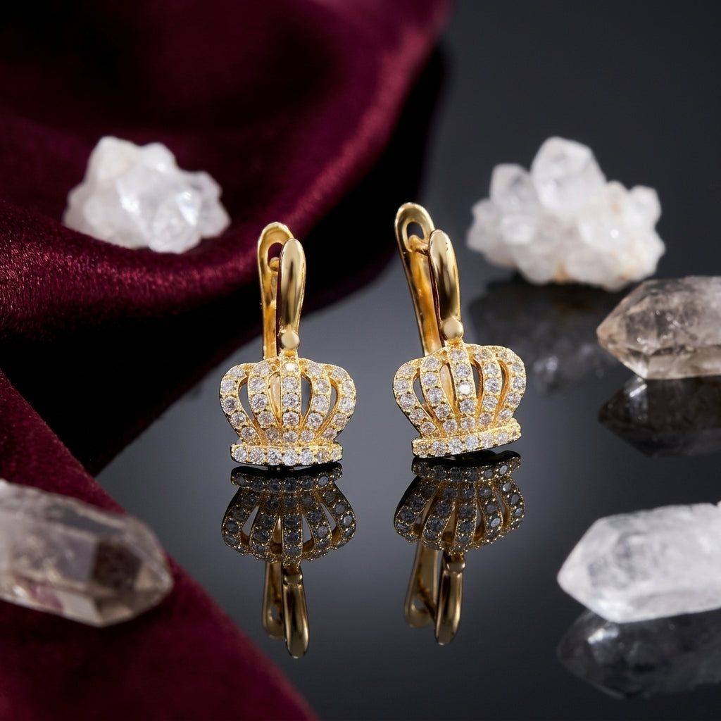 Gold-Tone Micro-Pavé CZ 3D Royal Crown Pendant Huggie Hoop Drop Statement Earrings on black mirror surface with white crystal quartz clusters and deep burgundy velvet backdrop