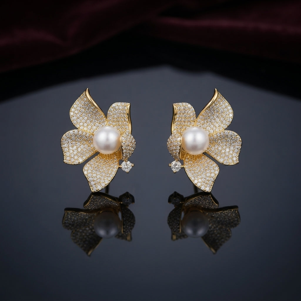 Gold-Tone Micro-Pavé CZ Orchid Flower Pearl Center Statement Stud Earrings on dark mirror surface with deep burgundy velvet backdrop