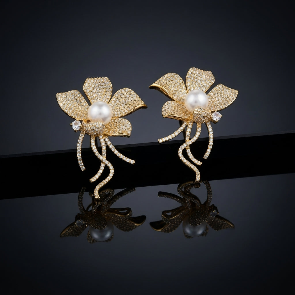 Gold-Tone Micro-Pavé CZ Wild Orchid Pearl Center & Pavé Tendril Stem Statement Earrings on black mirror surface with dark background