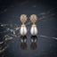 Gold-Tone Mixed-Cut CZ Dome Cluster Cap & Baroque Pearl Teardrop Drop Earrings on dark marble surface with navy blue silk fabric backdrop