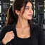 Gold Mughal Filigree Orb Pendant Necklace worn by model in black gym jacket at gym setting with black dumbbell rack backdrop