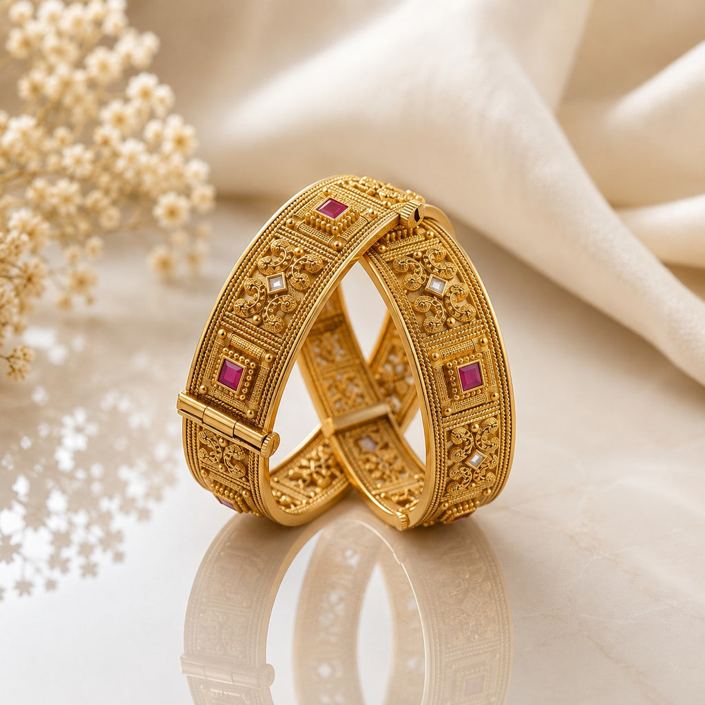 Gold-Tone Mughal Scroll Filigree Ruby & White CZ Square Panel Kada Bangle Set of 2 on cream marble surface with white silk fabric and baby's breath flowers backdrop