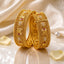 Gold-Tone Mughal Temple Granule Polki & Ruby CZ Panel Wide Kada Bangle Set of 2 on cream reflective surface with white silk fabric, pearls and rose petals backdrop