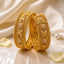 Gold-Tone Mughal Temple Granule Polki & Ruby CZ Wide Kada Bangle Set of 2 stacked on cream reflective surface with ivory silk fabric and rose petals backdrop