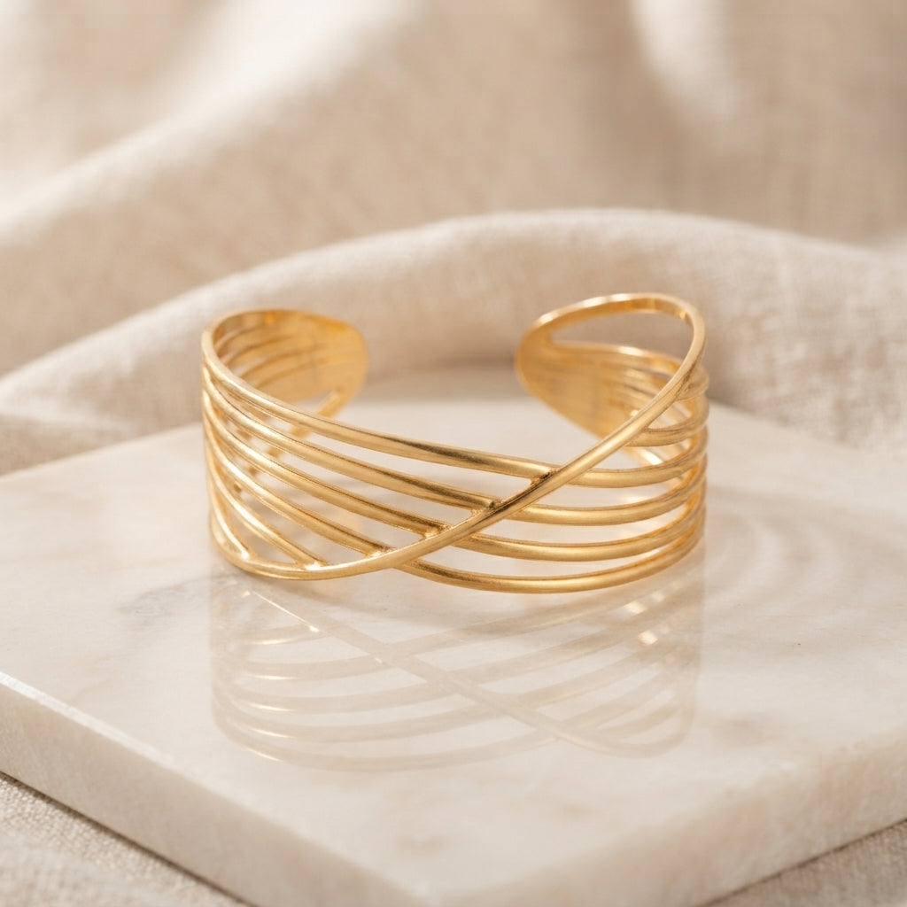 Gold Multi-Wire Crossover Open Cuff Bangle on white marble tile with cream linen drape backdrop