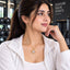 Gold Open Heart CZ Solitaire & Pavé Arm Pendant Necklace worn by model in white gym jacket at gym setting