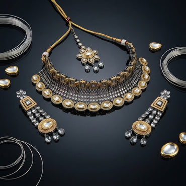 22K Gold & Oxidized Silver Dual-Tone Large Oval Polki Kundan Diamond-Cut Mesh Wide Bib Choker Necklace Drop Earrings & Maang Tikka 3-Piece Bridal Set on black mirror surface with silver wire coils and gold polki pear stone props backdrop