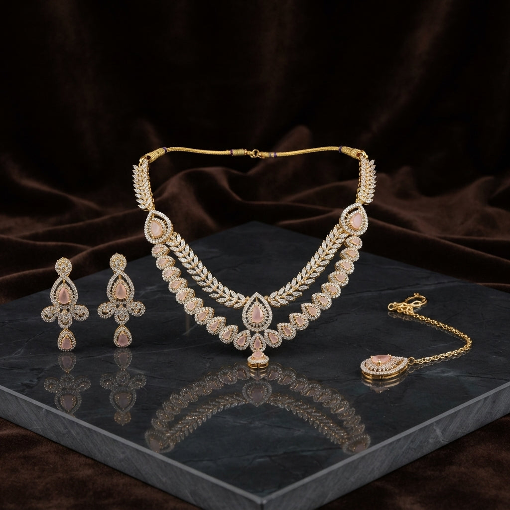 Gold Peach CZ Halo Double Layer Pear Necklace Drop Earrings & Maang Tikka Bridal Set on dark grey marble surface with dark brown velvet drape backdrop