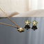 Gold Pearl and CZ Star Flower Pendant Necklace and Stud Earrings Set in Emerald Green on grey slate mirror with cream linen backdrop showing 18K gold cable chain with 5-petal star flower pendant with emerald green micro-pave CZ border champagne CZ inner petals freshwater pearl centre and matching star flower stud earrings