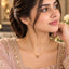 Gold Pink CZ Heart Bezel Solitaire Pendant Necklace worn by bridal model in blush pink embroidered lehenga with gold bokeh floral backdrop