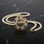 gold-plated double strand pearl necklace with a circular pendant featuring Arabic Allah calligraphy surrounded by a sunburst crystal halo, shown on a dark reflective surface.