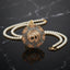 gold-plated double strand pearl necklace with a circular pendant featuring Arabic Allah calligraphy surrounded by a sunburst crystal halo, shown on a dark reflective surface.