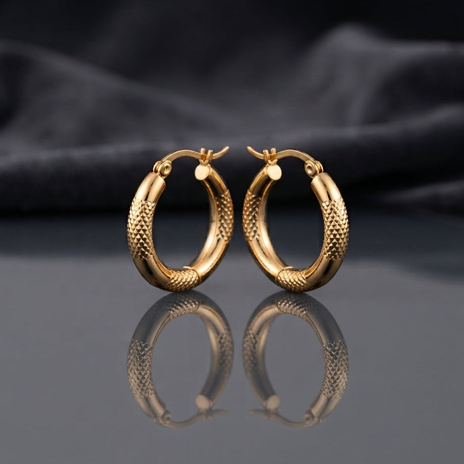 Gold PVD Stainless Steel Diamond-Cut Texture and Smooth Tube Hoop Earrings pair standing side by side on dark mirror surface with charcoal slate satin backdrop showing 18K gold PVD coated stainless steel hoops with diamond-cut pyramid texture outer half smooth mirror-polish inner half and polished barrel accent cap at base with French lever closure and sharp mirror reflection below