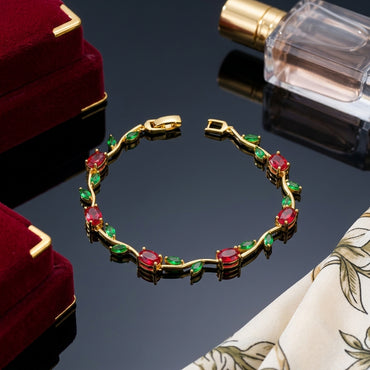 Gold-Tone Multicolor CZ Oval & Marquise Vine Wave Tennis Bracelet on dark reflective surface with gold satin ribbon and perfume bottle backdrop