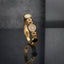 Gold Roman Numeral CZ Pave Triple Disc Bangle in 18K gold-tone plating on dark grey mirror surface showing slim rigid open oval link band bangle with white enamel disc at top CZ pave dome with Roman numeral engraved gold border at centre and black onyx disc at bottom with push-button fold-over clasp and mirror reflection below