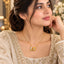 Gold Rose Bloom CZ Solitaire & Pavé Leaf Pendant Necklace worn by bridal model in cream pearl-embroidered lehenga portrait with white floral and gold mirror backdrop