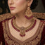 Gold-Tone Ruby Red Bead Filigree Choker & Chandbali Bridal Jewelry Set worn on Pakistani female model in deep maroon velvet embroidered bridal dress with dark studio backdrop — close-up detail