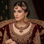 Gold-Tone Ruby Red Bead Filigree Choker & Chandbali Bridal Jewelry Set worn on Pakistani female bridal model in deep maroon velvet lehenga seated on ornate bridal chair with burgundy curtain backdrop