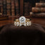 Gold Solitaire CZ & Marquise Wheat Band Bridal Stackable Ring Set on dark brown velvet ring cushion with vintage books backdrop
