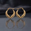Gold Textured Feather Leaf Twist Teardrop Hoop Earrings pair standing upright on dark mirror surface with charcoal slate satin backdrop showing 22K antique gold-tone pair with two herringbone feather-engraved bands twisting around each other in pointed teardrop flame silhouette with hinged latch-back closure and sharp mirror reflection below