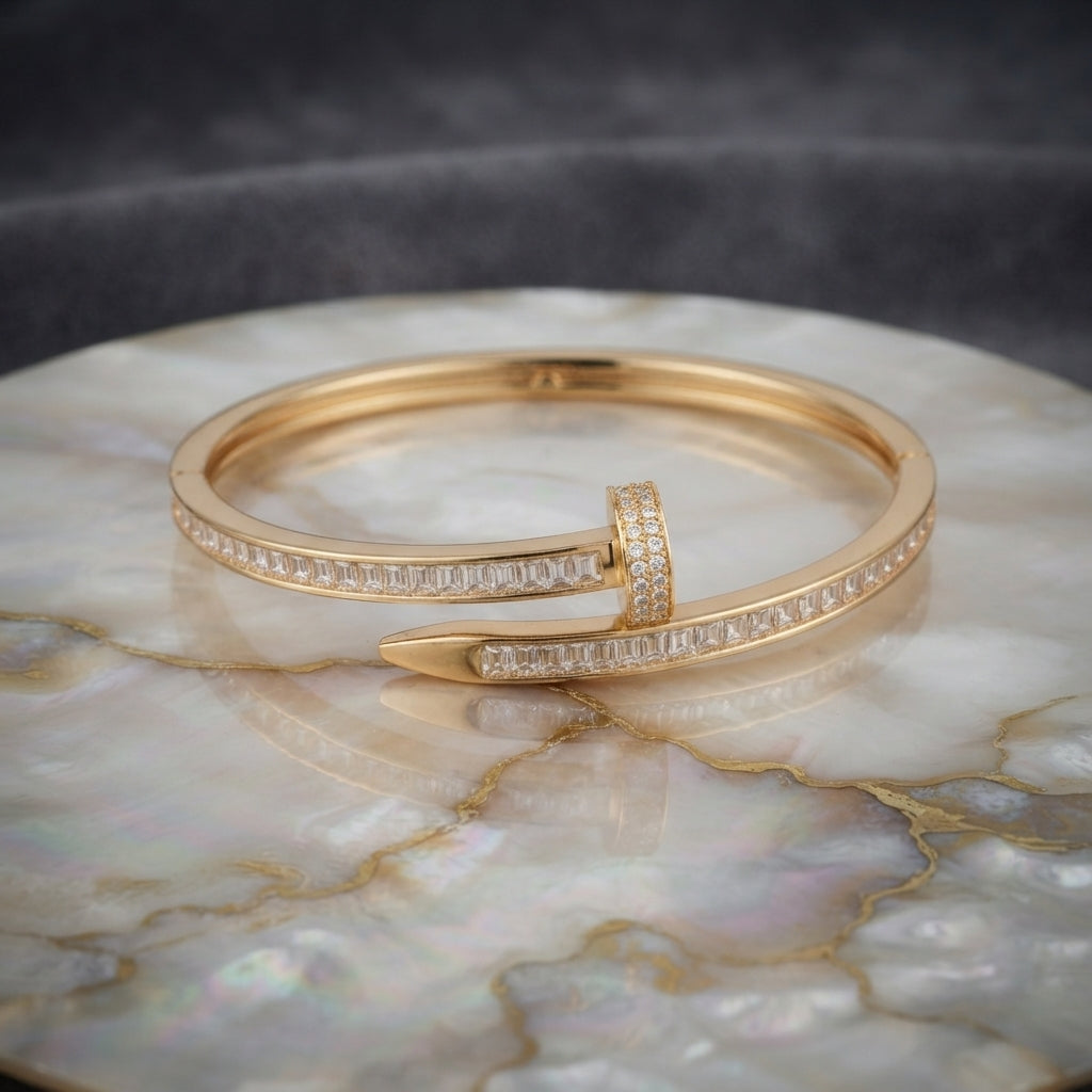 Gold-tone baguette CZ nail bypass bangle with channel-set stones and pointed tip