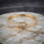 Gold-tone baguette CZ nail bypass bangle with channel-set stones and pointed tip